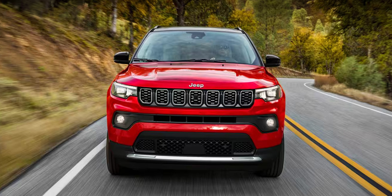 A red 2025 Jeep Compass facing towards us in POV.