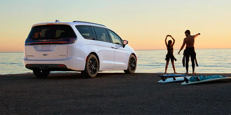 Two people at a beach with their 2025 Chrysler Pacifica near Fort Gratiot, MI