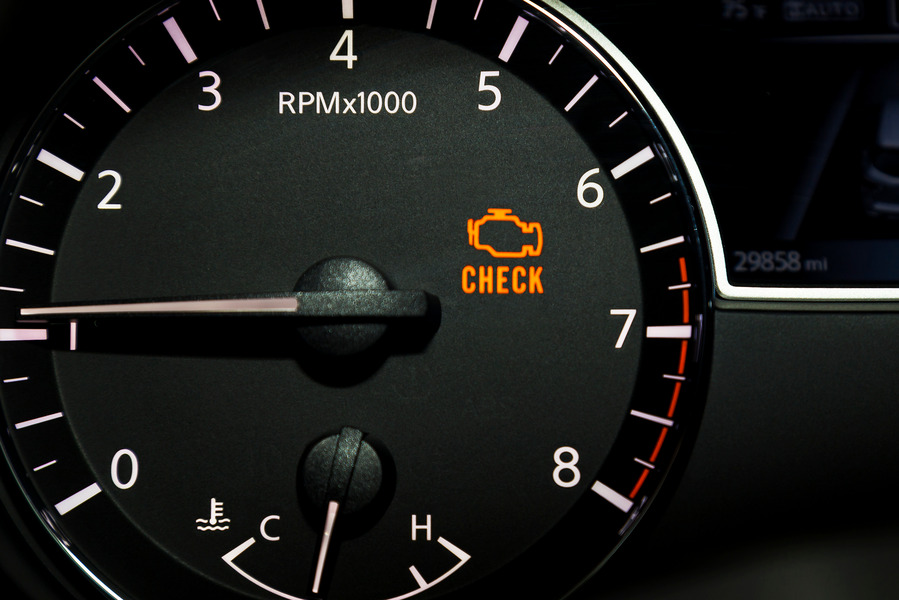 Illuminated check engine light on a car dashboard tachometer.